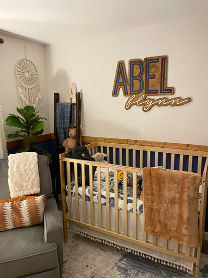 The Abel Flynn layered personalized wood name sign in a nursery