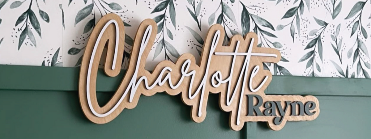 Charlotte Rayne layered personalized name sign on a green wall